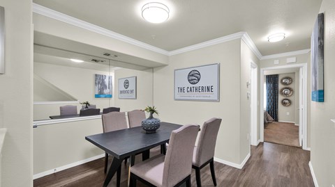 A dining room with a table and chairs and a sign that says "The Catherine".