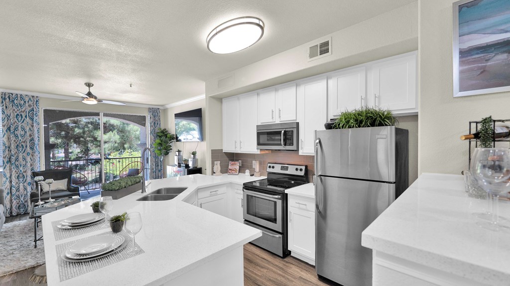 A modern kitchen with stainless steel appliances and white countertops.
