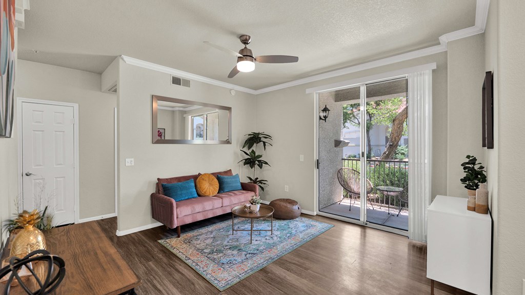 A living room with a pink couch and a ceiling fan.
