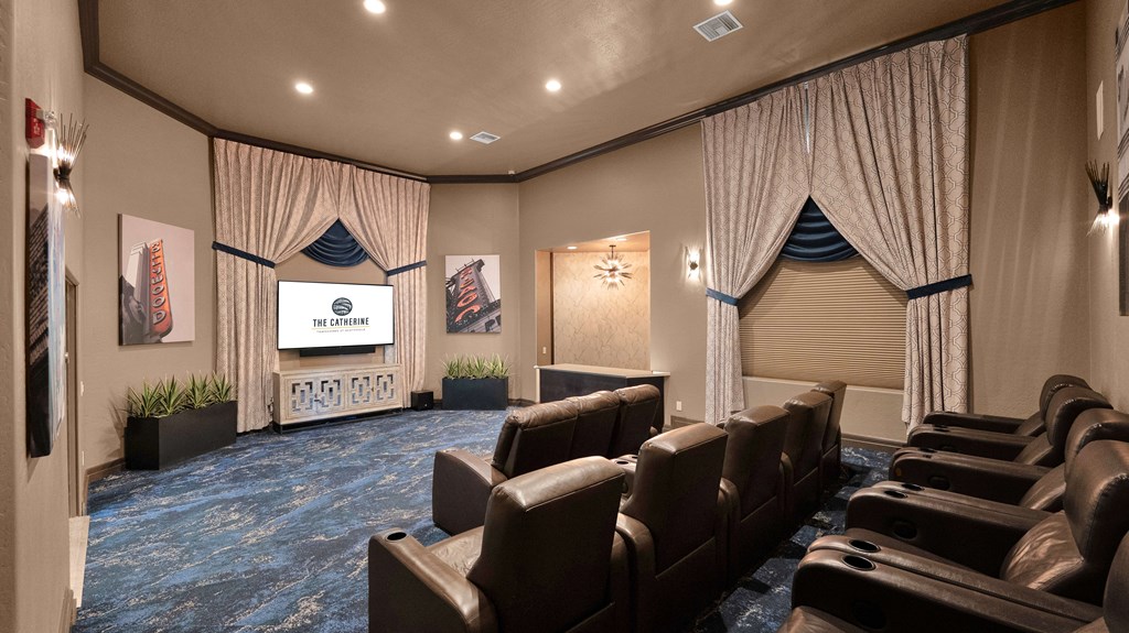 A home theater with a screen and a row of leather chairs.