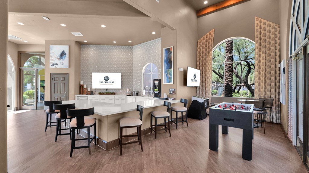 A room with a foosball table and a bar area.