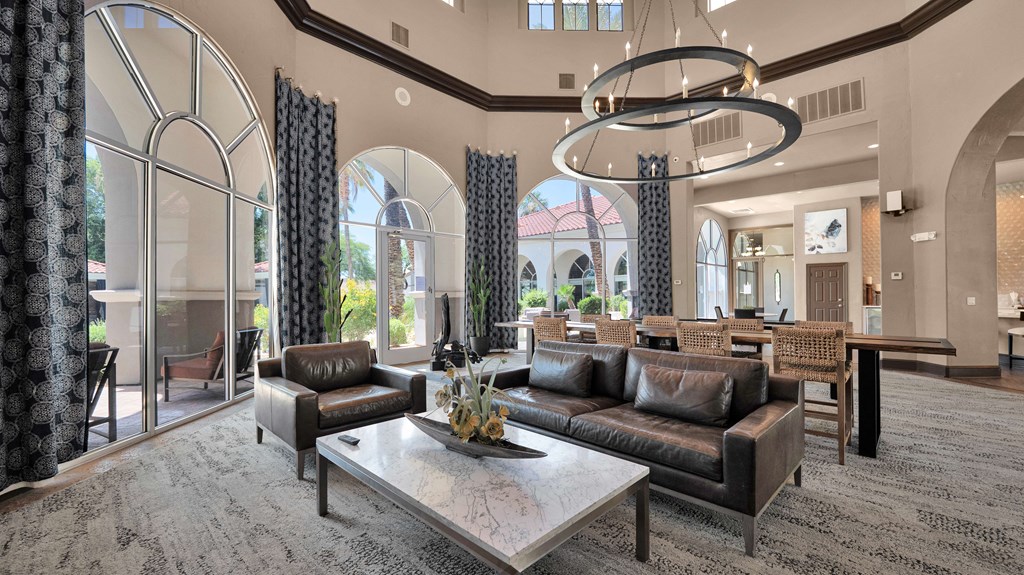 A large, modern living room with a central coffee table and a large chandelier.