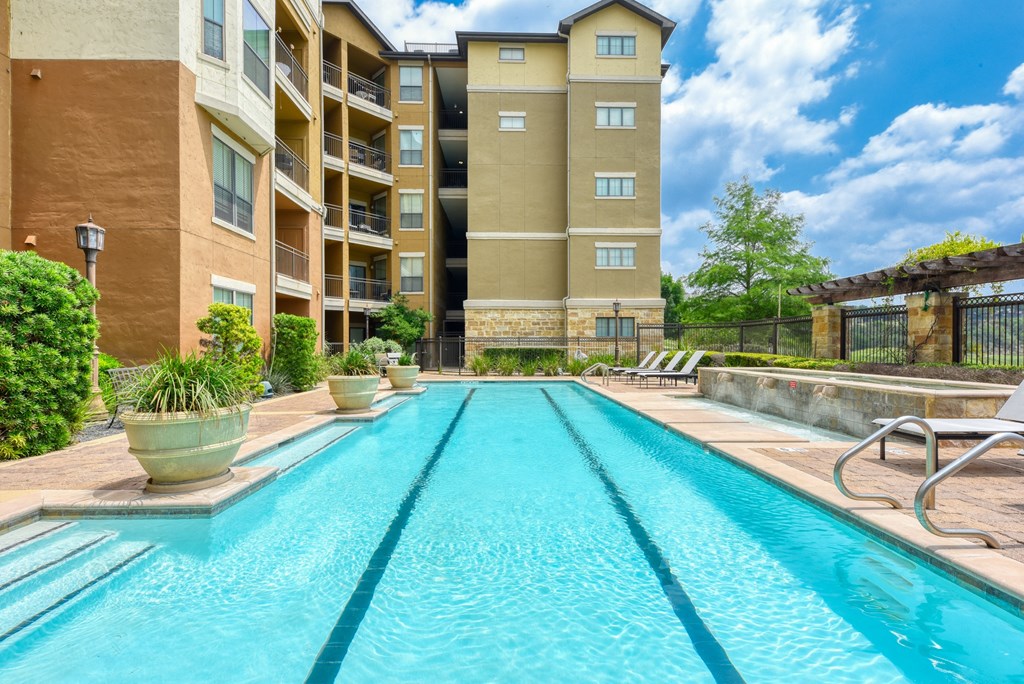a swimming pool with an apartment building in the background