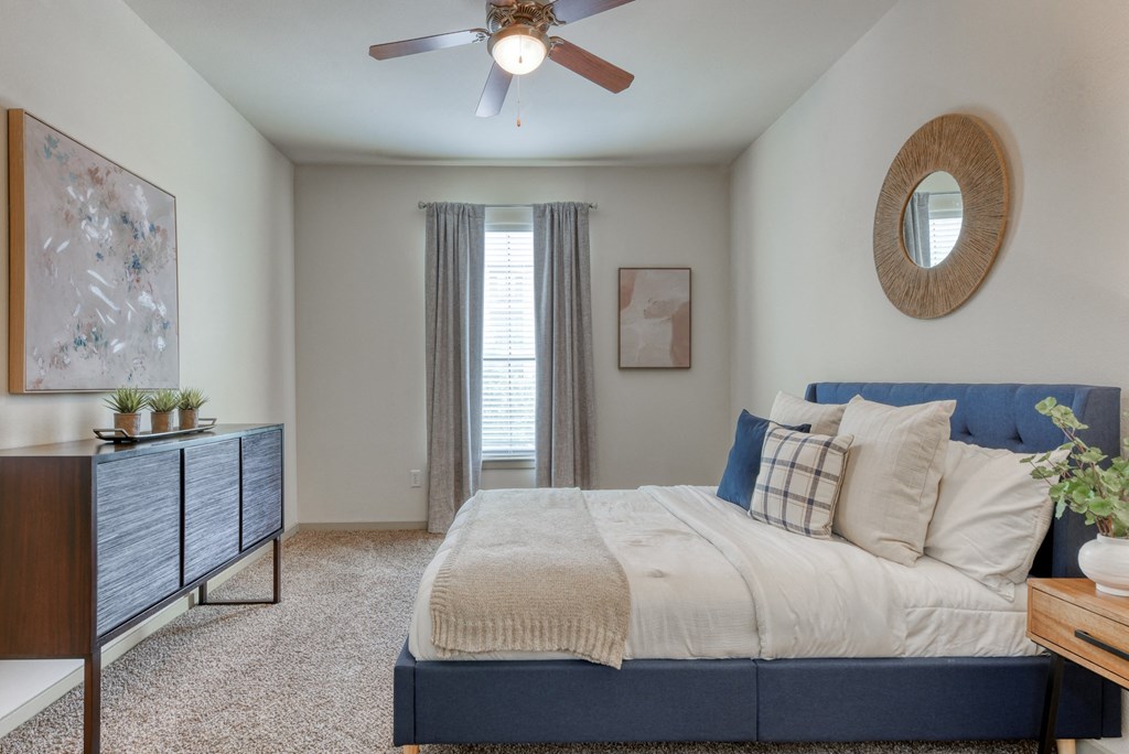 a bedroom with a large bed and a ceiling fan