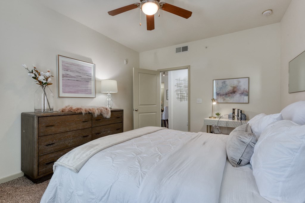 a bedroom with a large bed and a ceiling fan
