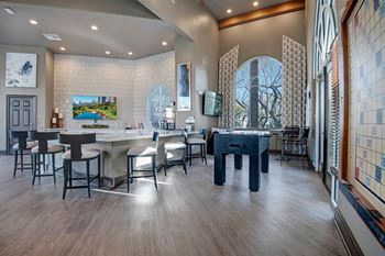 A room with a bar and a pool table.