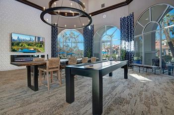 A modern dining room with a glass table and chairs.