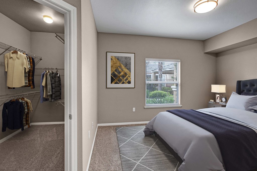 A bedroom with a large bed and a wardrobe with clothes hanging.