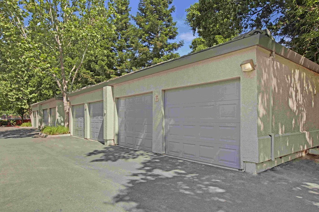 A green building with a grey garage door.