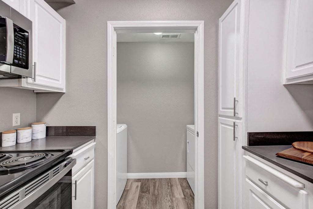 A kitchen with white cabinets and a black stove top.