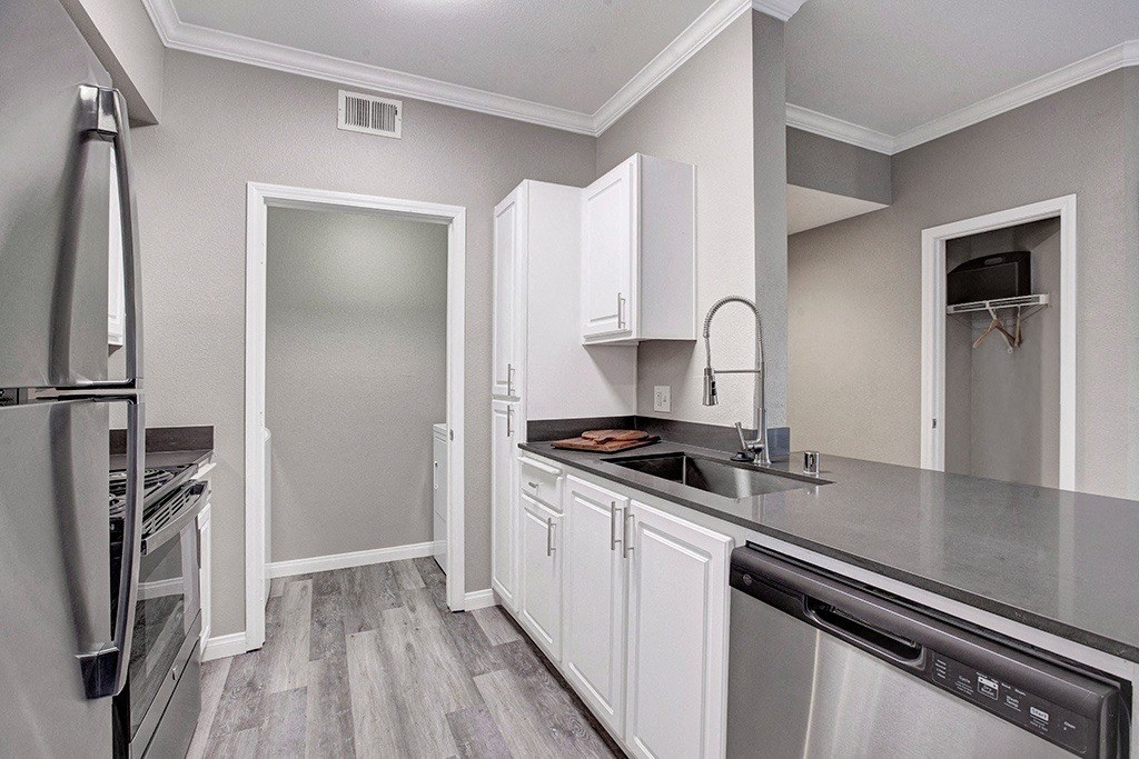 A kitchen with white cabinets and stainless steel appliances.