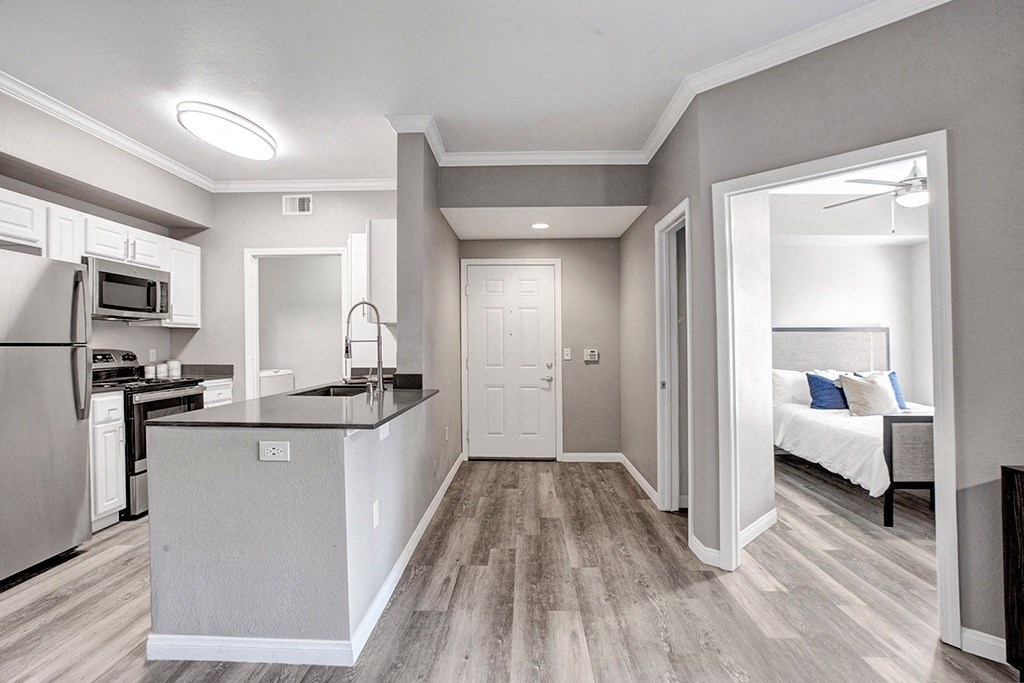 A kitchen with a refrigerator, microwave, and stove top oven.