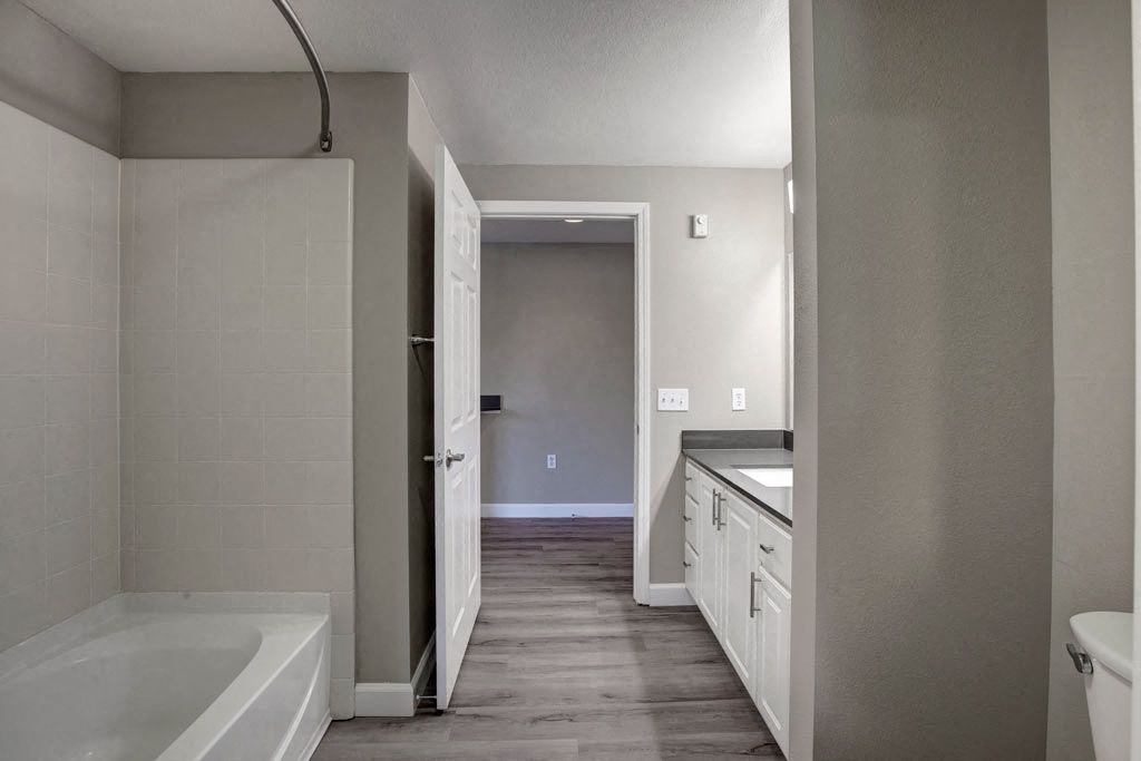 A bathroom with a white tub and a white door.