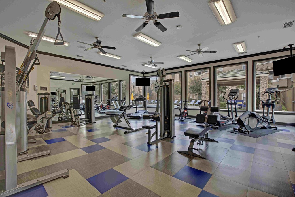 A gym with a variety of equipment including weights and machines.