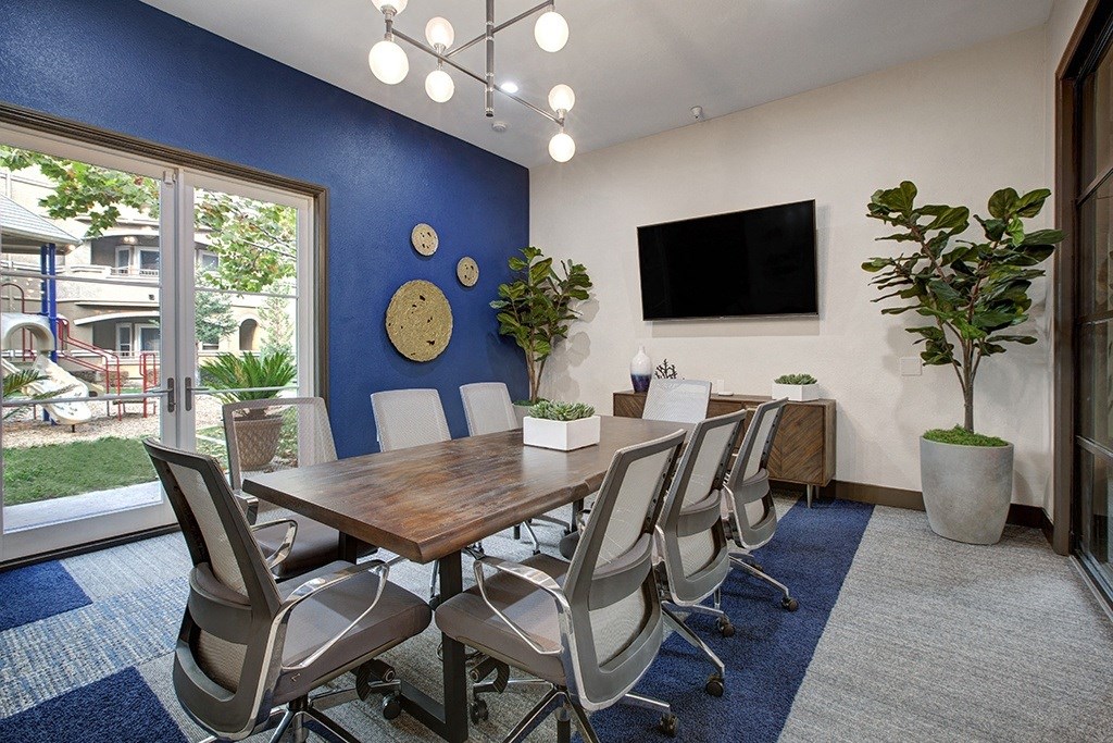 A conference room with a long table and chairs.