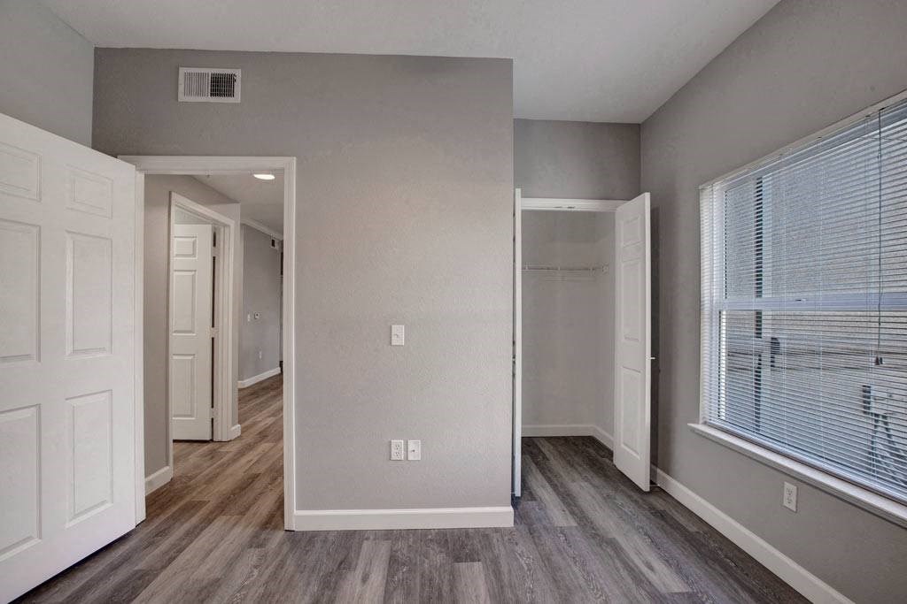 A room with a white door and a window with blinds.