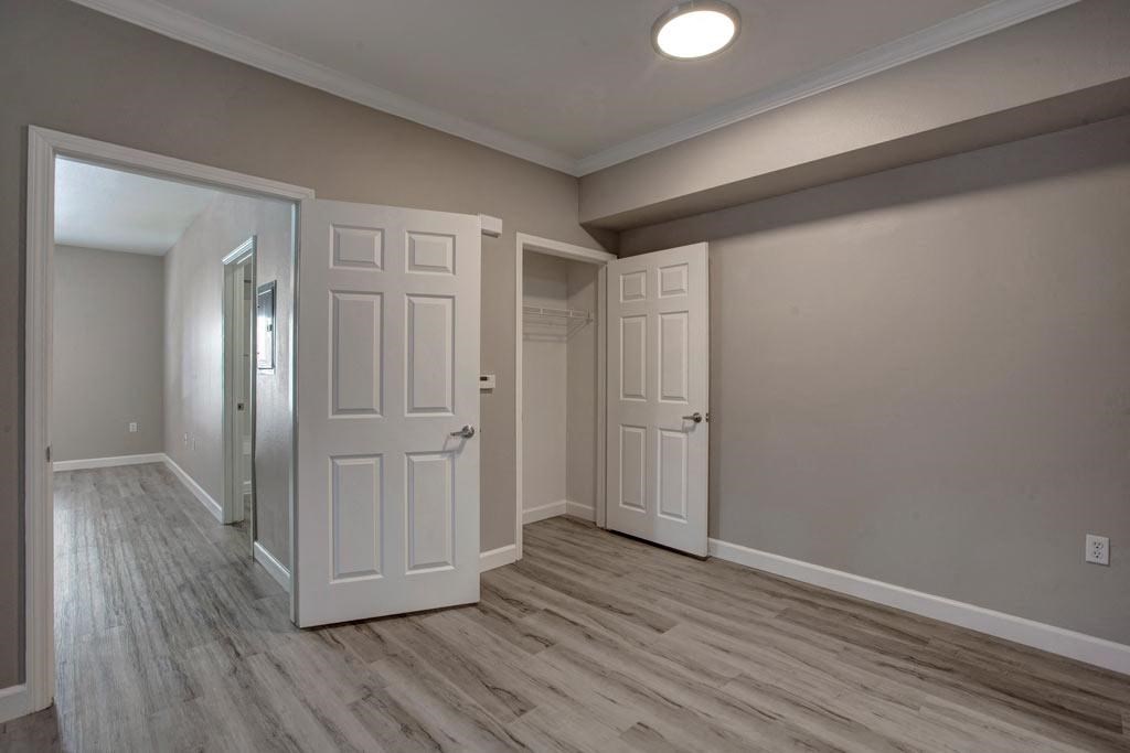 A room with a white door and a grey wall.
