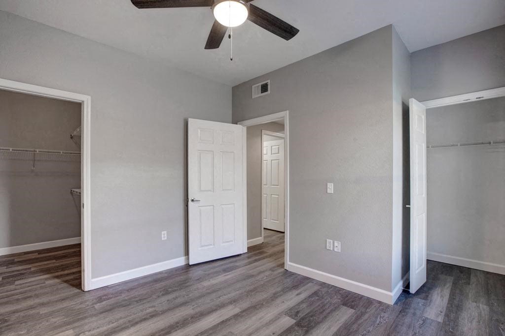 A room with a ceiling fan and a door.