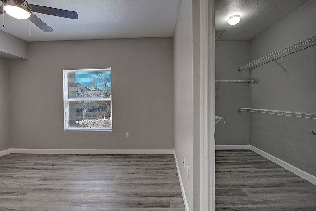 A room with a window and a fan.