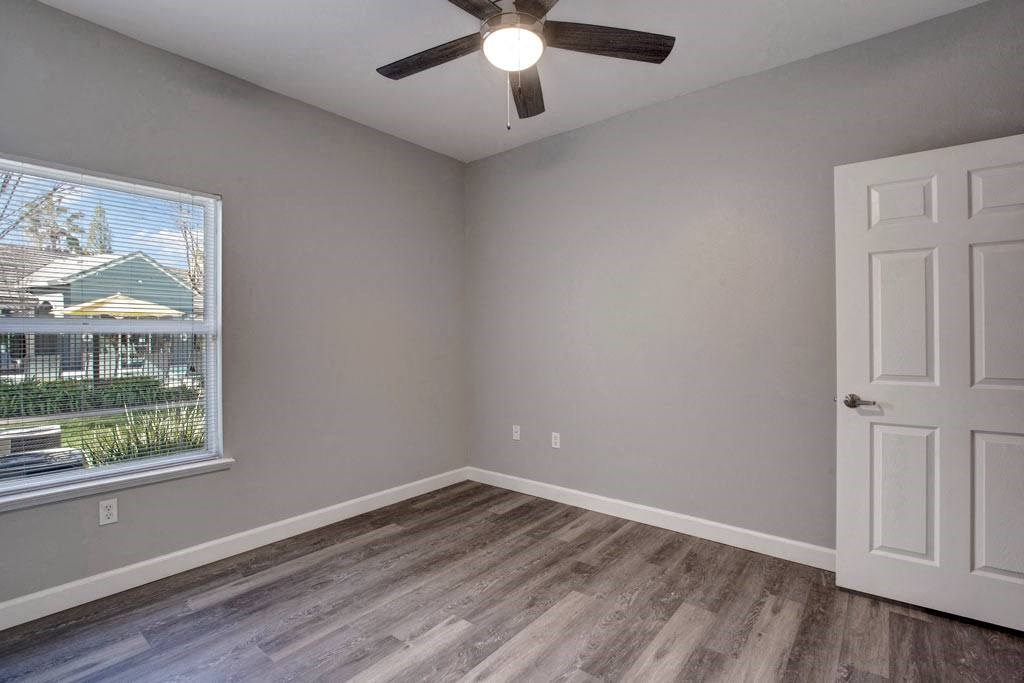 A room with a ceiling fan and a door.