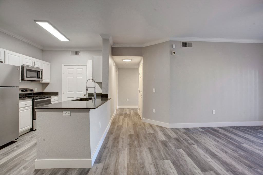 A kitchen with a refrigerator, microwave, and oven.