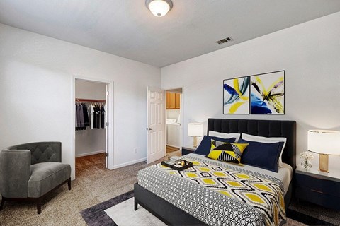 A bedroom with a large bed and a chair.