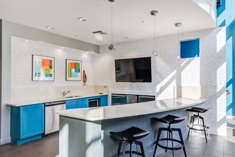 A kitchen with a white counter top and blue cabinets.
