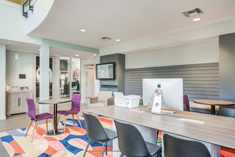 A modern office space with a colorful rug and a wooden table.