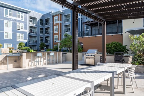 A patio with a table and chairs is surrounded by apartment buildings.