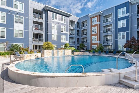 A swimming pool in front of apartment buildings.
