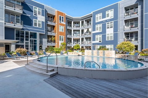 A pool in a courtyard surrounded by apartment buildings.