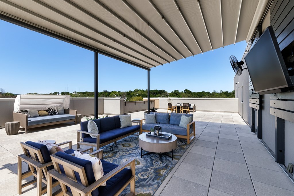 A patio with a table and chairs under a roof.