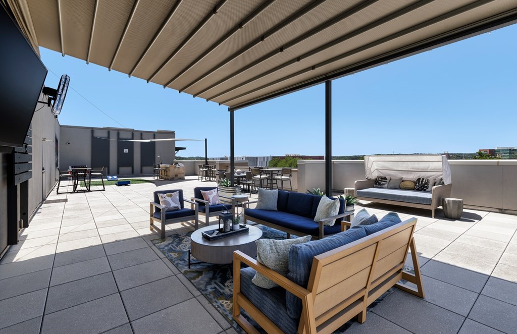 A patio with a table and chairs under a roof.
