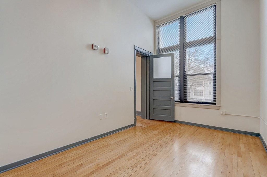 an empty living room with a window and a door to a closet
