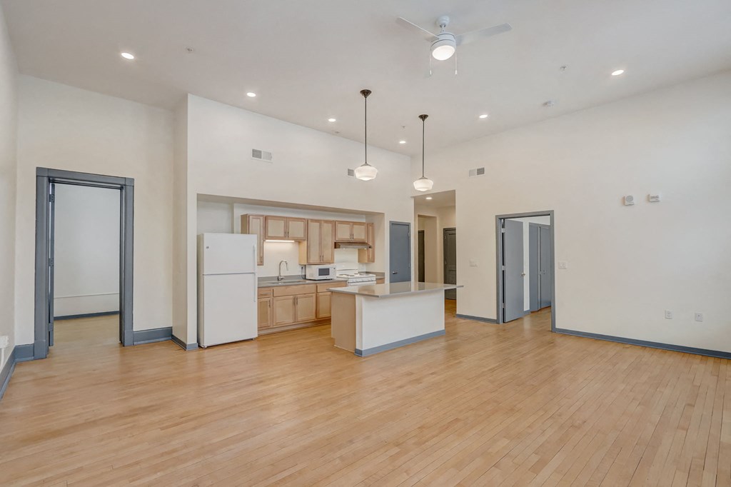 the living room and kitchen of a new home with wood flooring and white walls