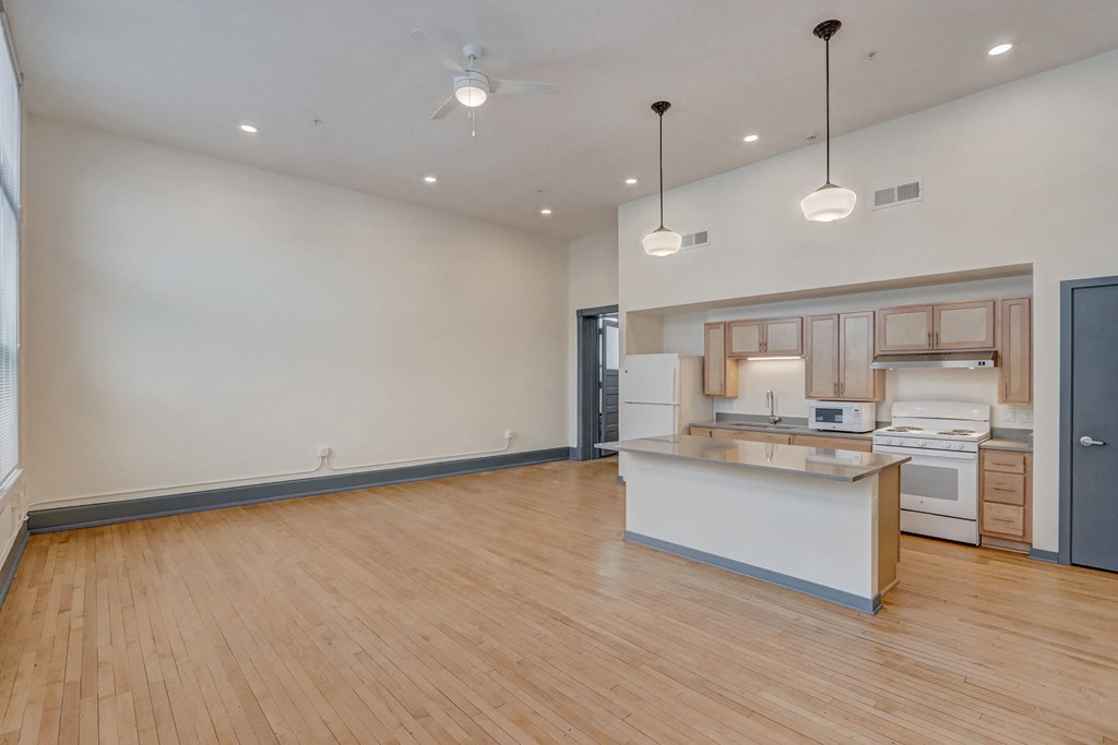 an open kitchen and living room with a large island and wood flooring