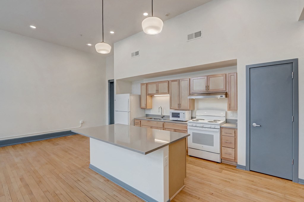 a kitchen with an island and a door to a living room
