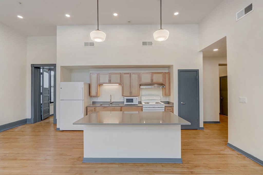 a kitchen with a white counter top and a refrigerator