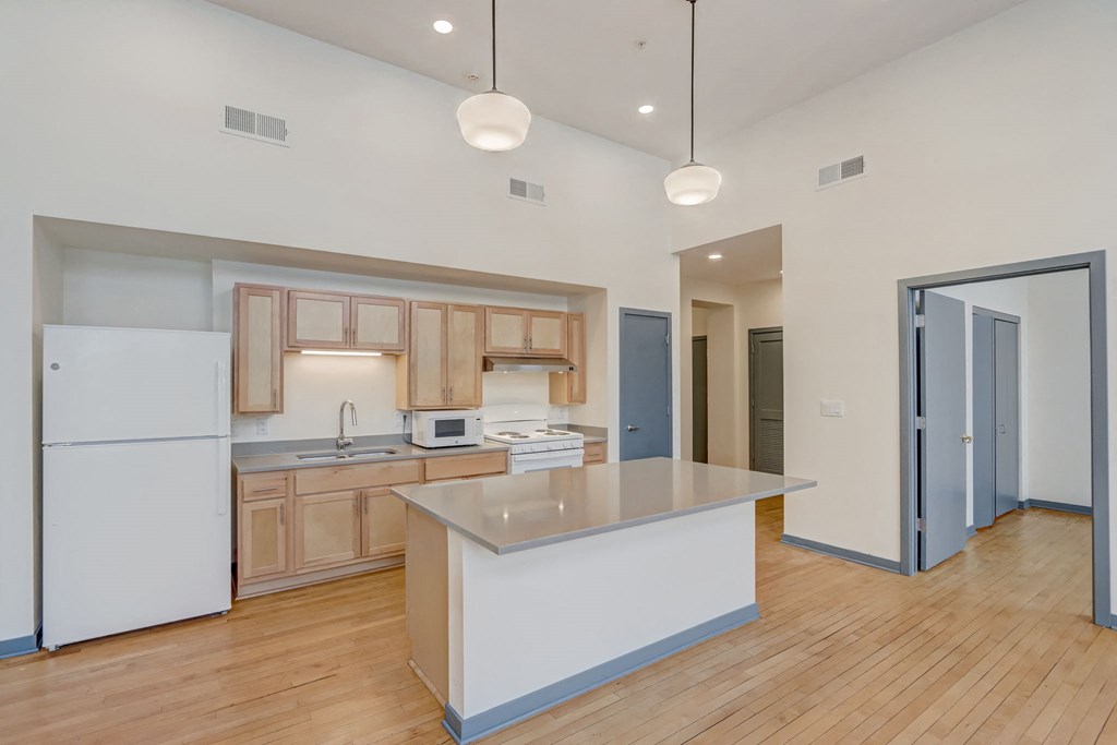 a kitchen with a large island and a white refrigerator