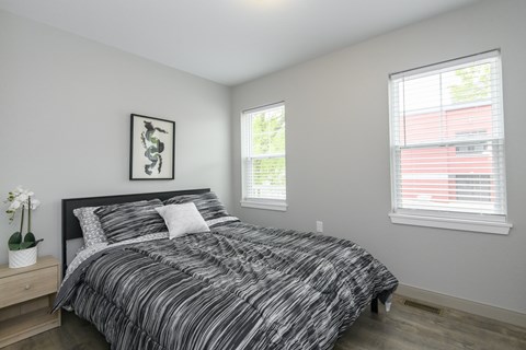 A bedroom with a large bed and a framed picture on the wall.