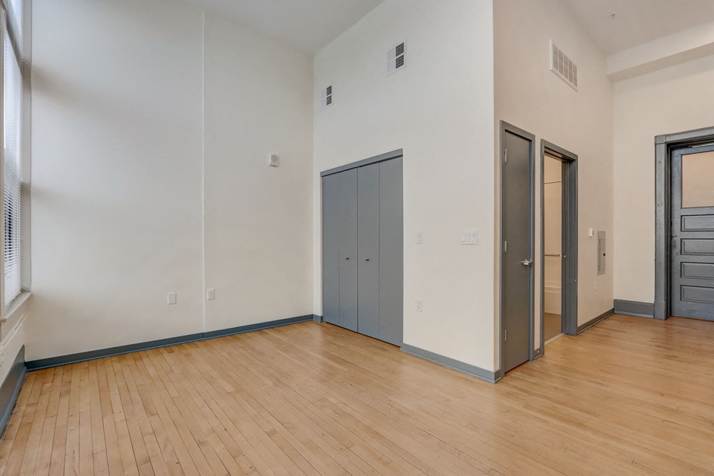 a living room with wood floors and white walls and grey doors