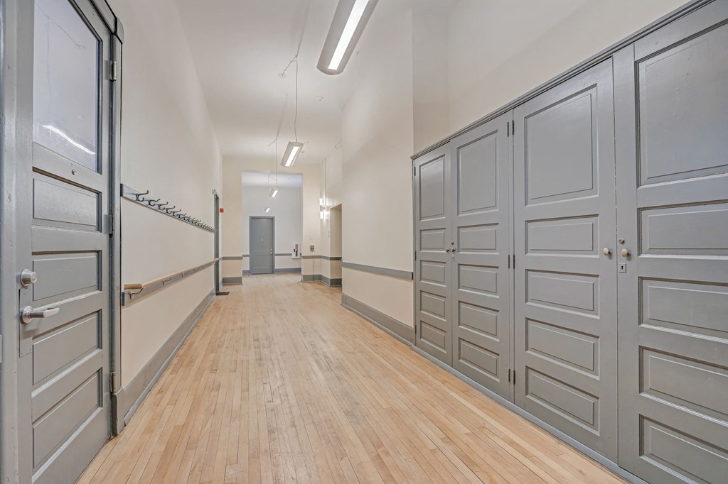 a long hallway with wood floors and white doors
