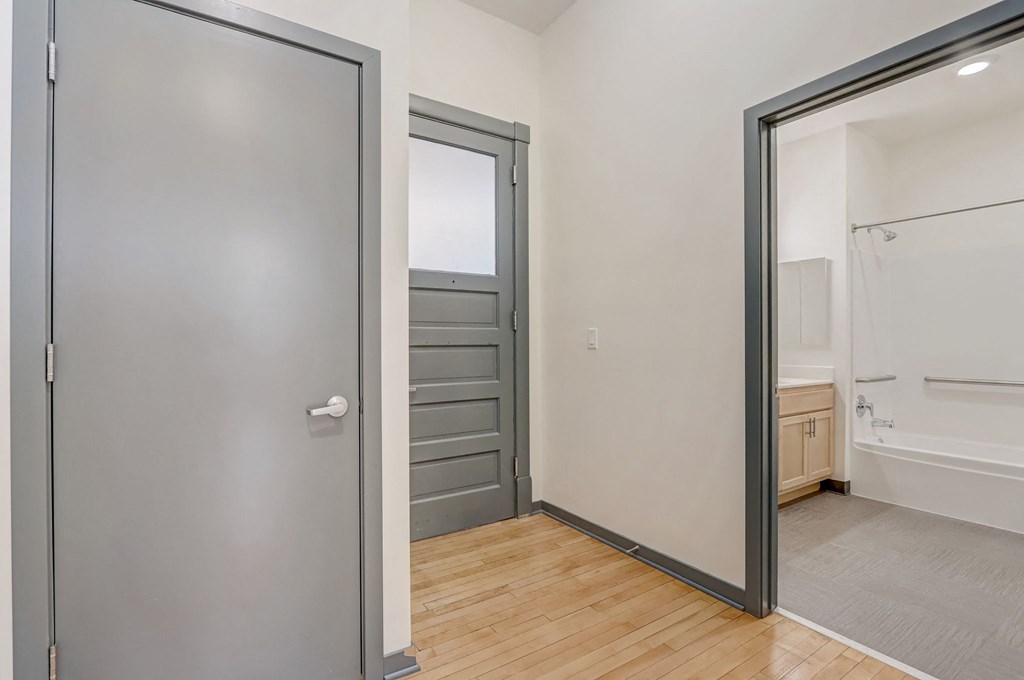 a bedroom with a door to a bathroom and a closet