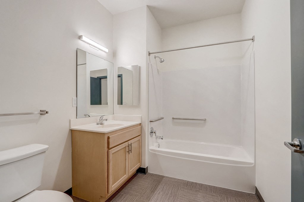a bathroom with a shower sink and toilet and a mirror