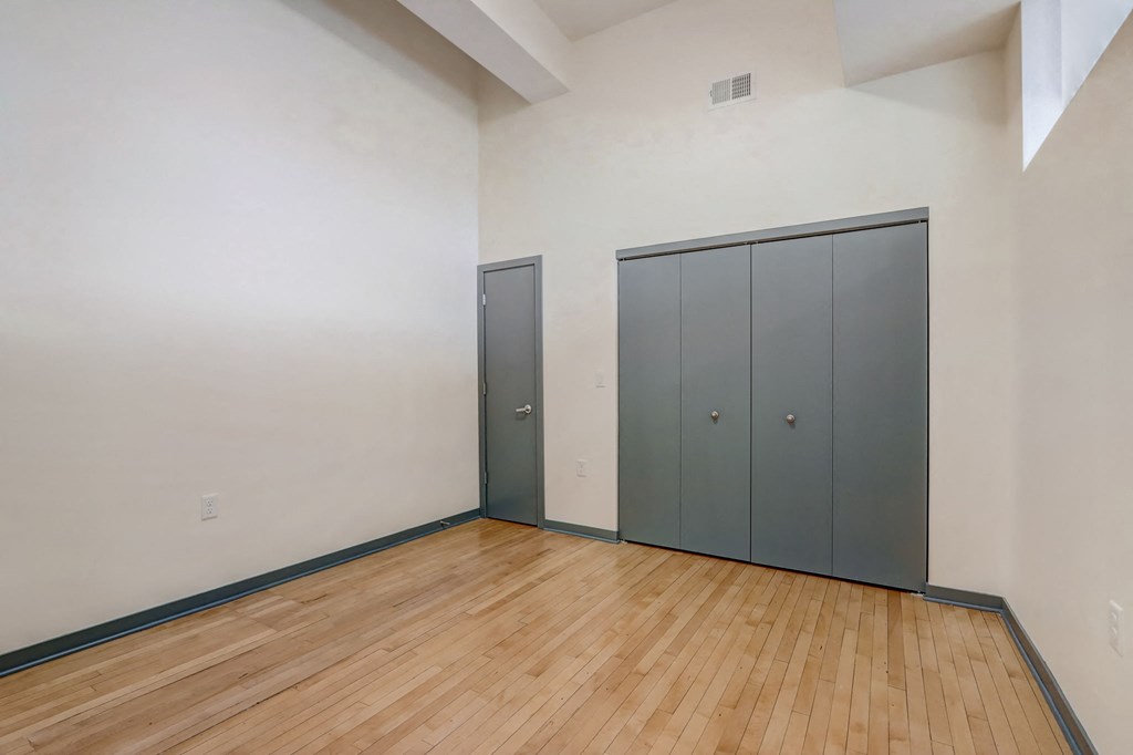 a room with wood flooring and two doors on the wall