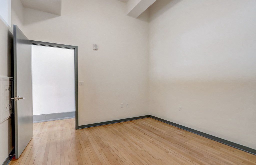 an empty room with white walls and a sliding glass door