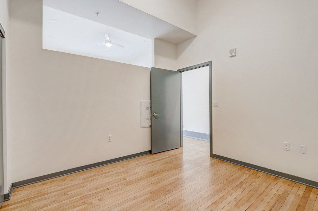a living room with white walls and wood floors and a sliding glass door