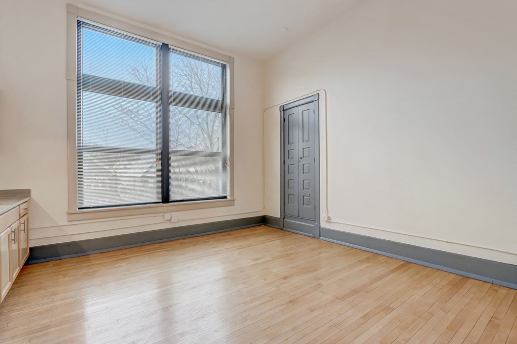 an empty living room with a door and window