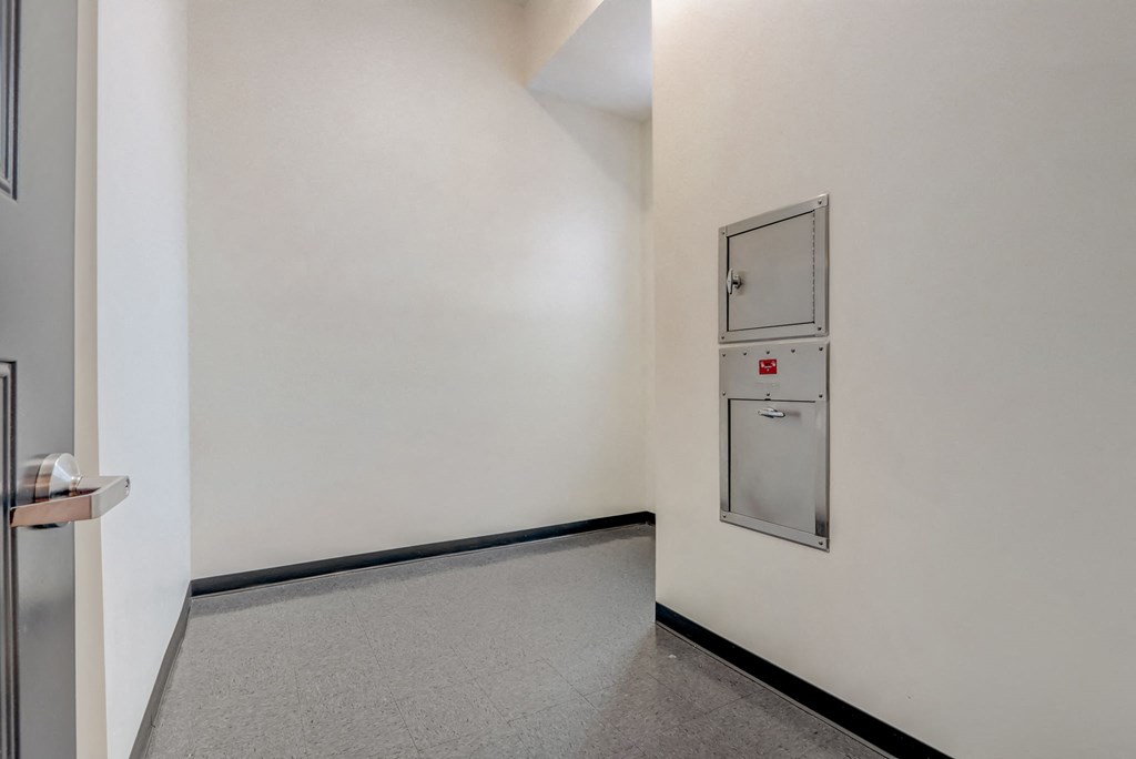 a white room with a refrigerator and a door on the wall