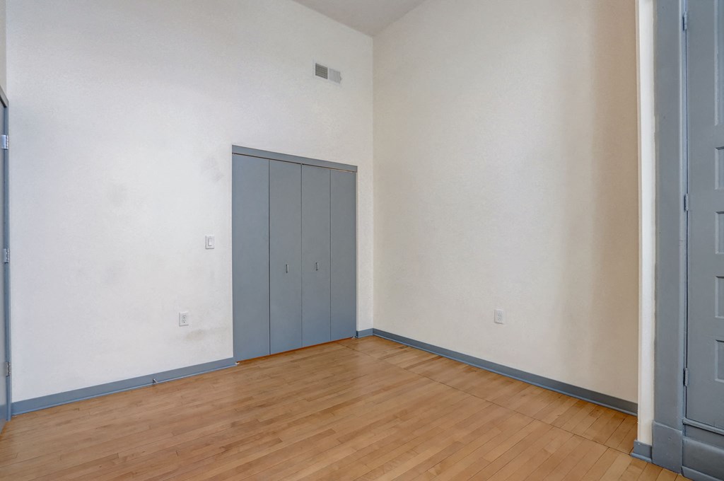 a room with a wood floor and white walls and a blue door